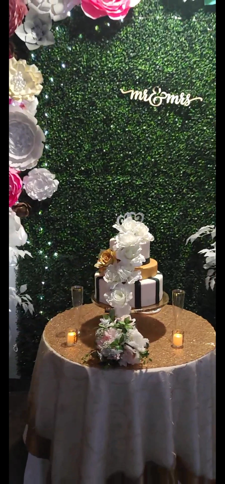 Three-tier wedding cake with "Mr & Mrs" backdrop